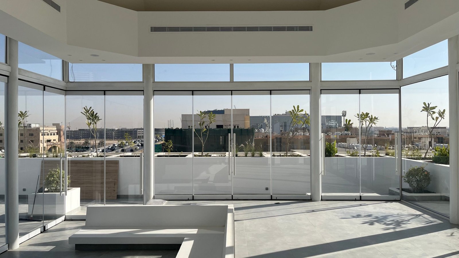 Bright interior space with panoramic views of Riyadh's cityscape, featuring modern architecture and sleek design.